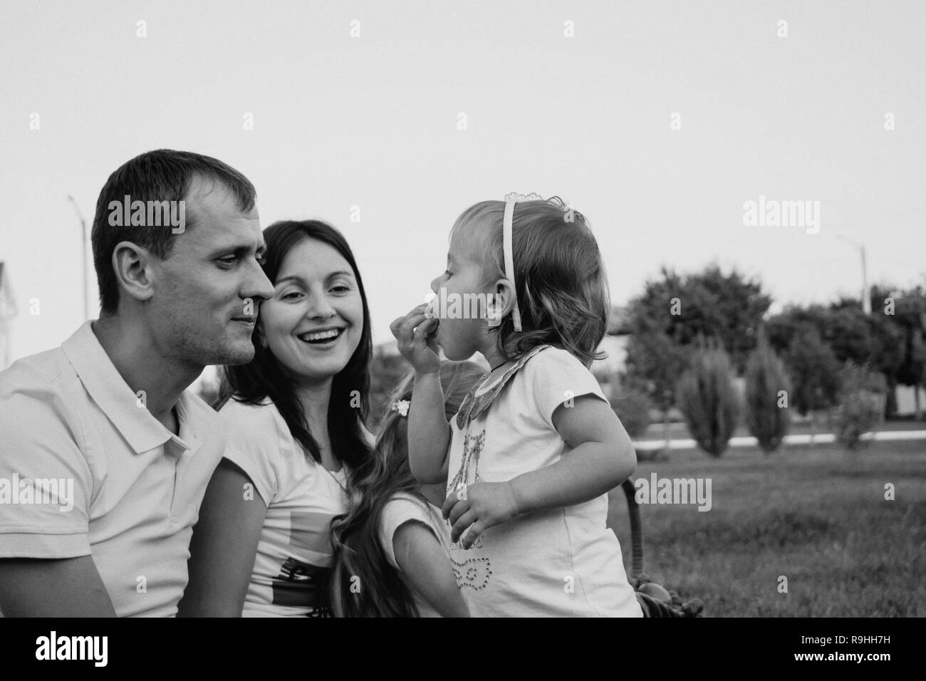 Carino famiglia felice nel parco hanno un sacco di divertimento insieme. giovani il padre e la madre e il loro dolce bambino Foto Stock