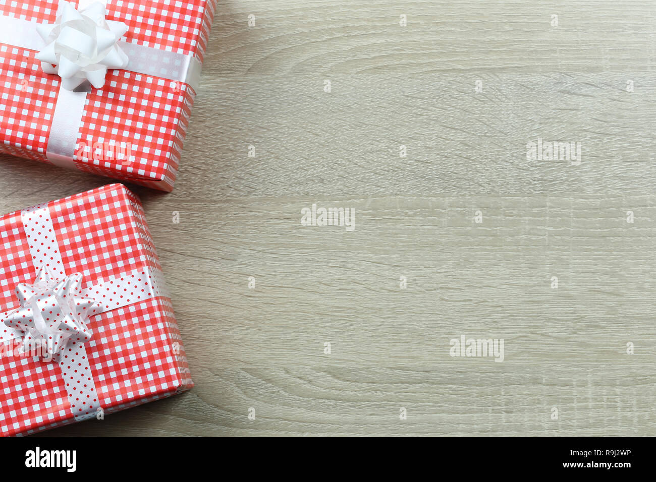 Confezione regalo rossa per la decorazione di Natale su pavimento di legno di sfondo e hanno spazio copia. Foto Stock