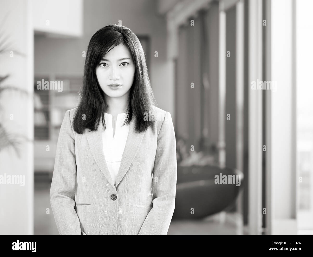 Office ritratto di una giovane asian business donna che guarda la telecamera in bianco e nero. Foto Stock