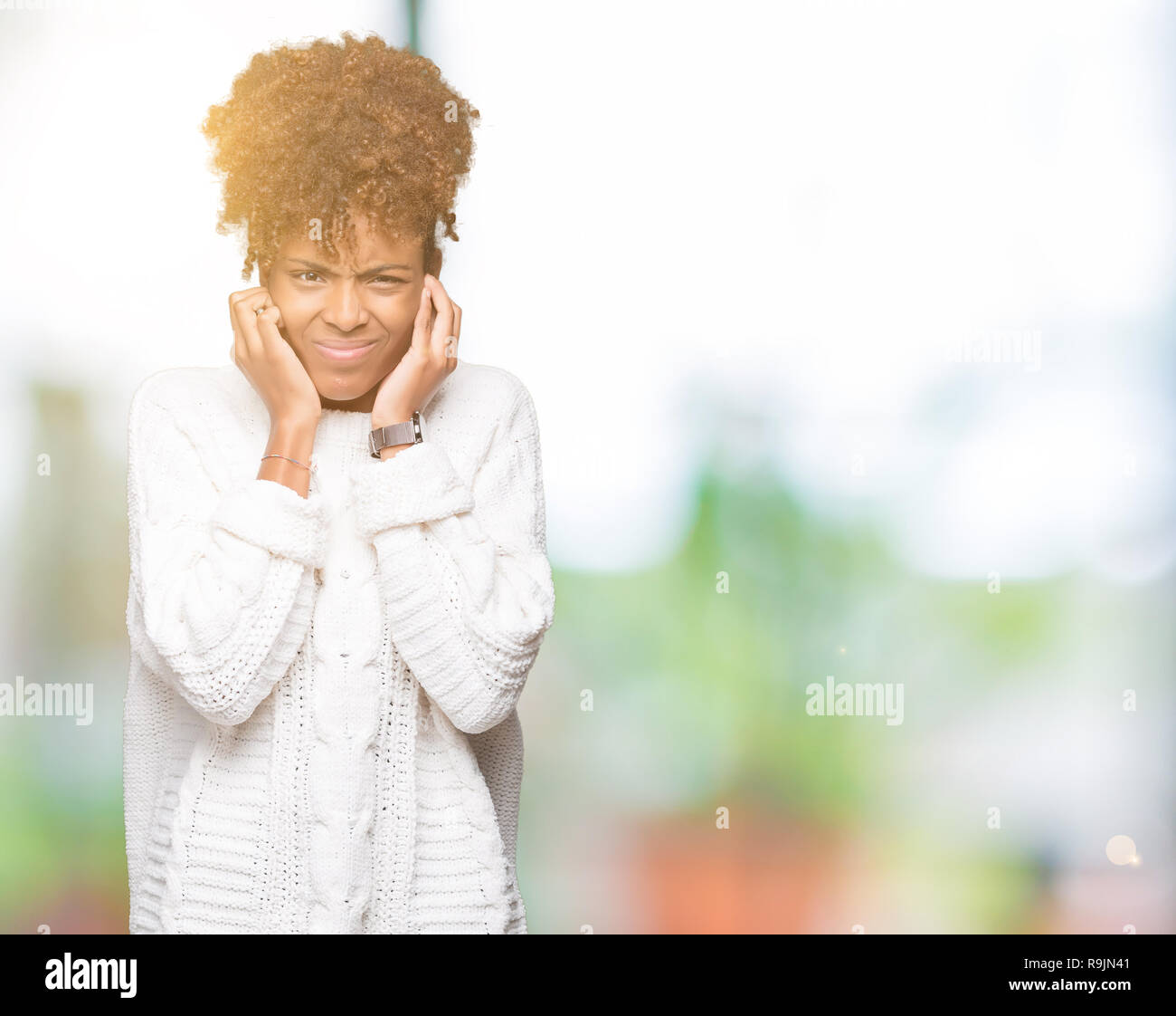 Bella giovane americano africano donna che indossa un maglione invernale su sfondo isolato che copre le orecchie con le dita con espressione di fastidio per la nois Foto Stock