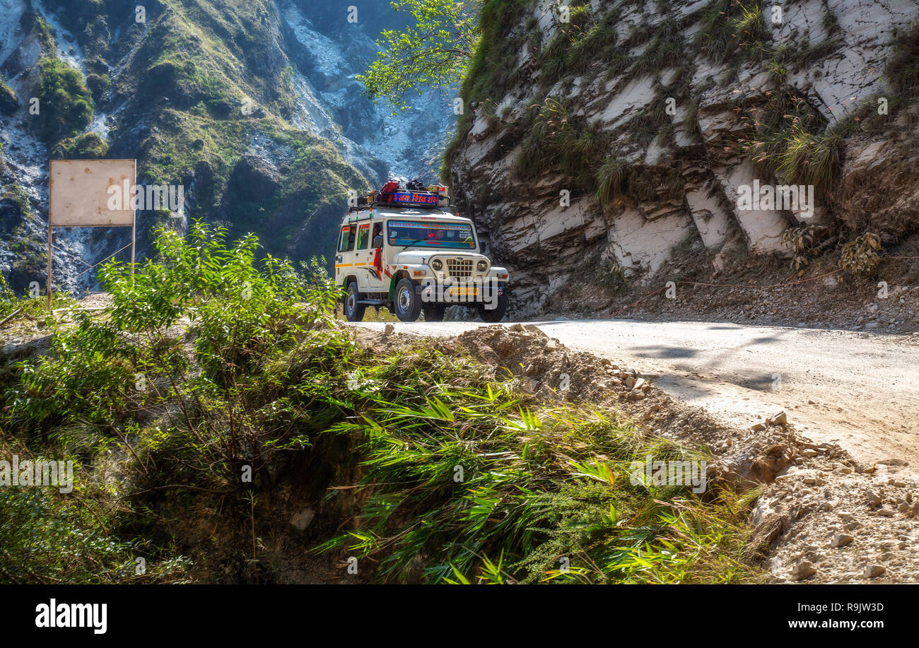 Di veicoli turistici sulla gita turistica viaggio attraverso le pericolose strade di montagna interessate da frana vicino Binsar Uttarakhand India. Foto Stock
