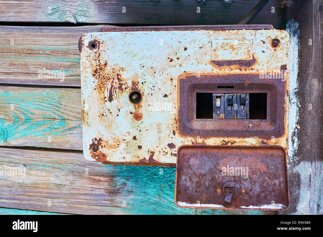 Un vecchio e rusty interruttore elettrico posto su una parete in metallo arrugginito box Foto Stock