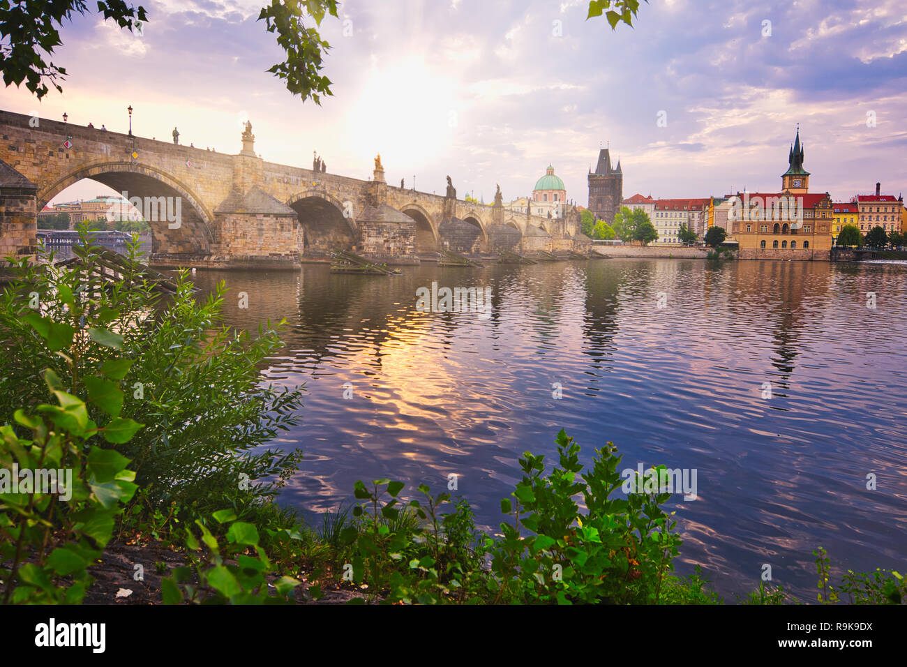 Alba al Ponte Carlo della città di Praga. Una fresca vista di mattina di Praga. Destinazione turistica per l'estate in Repubblica Ceca. Fogliame e paesaggio urbano. Foto Stock