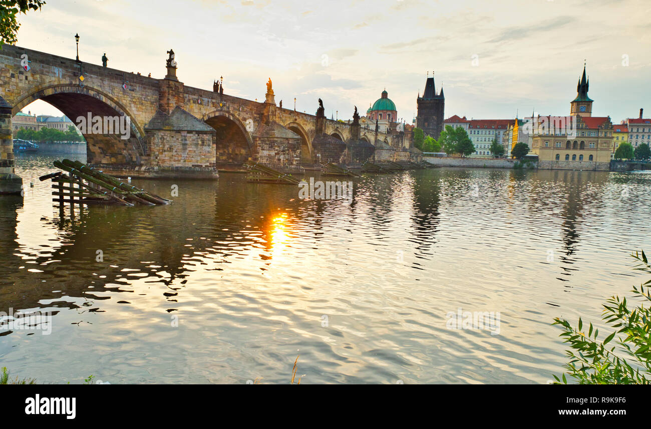 Alba al Ponte Carlo della città di Praga. Una fresca vista di mattina di Praga. Destinazione turistica per l'estate in Repubblica Ceca. Fogliame e paesaggio urbano. Foto Stock