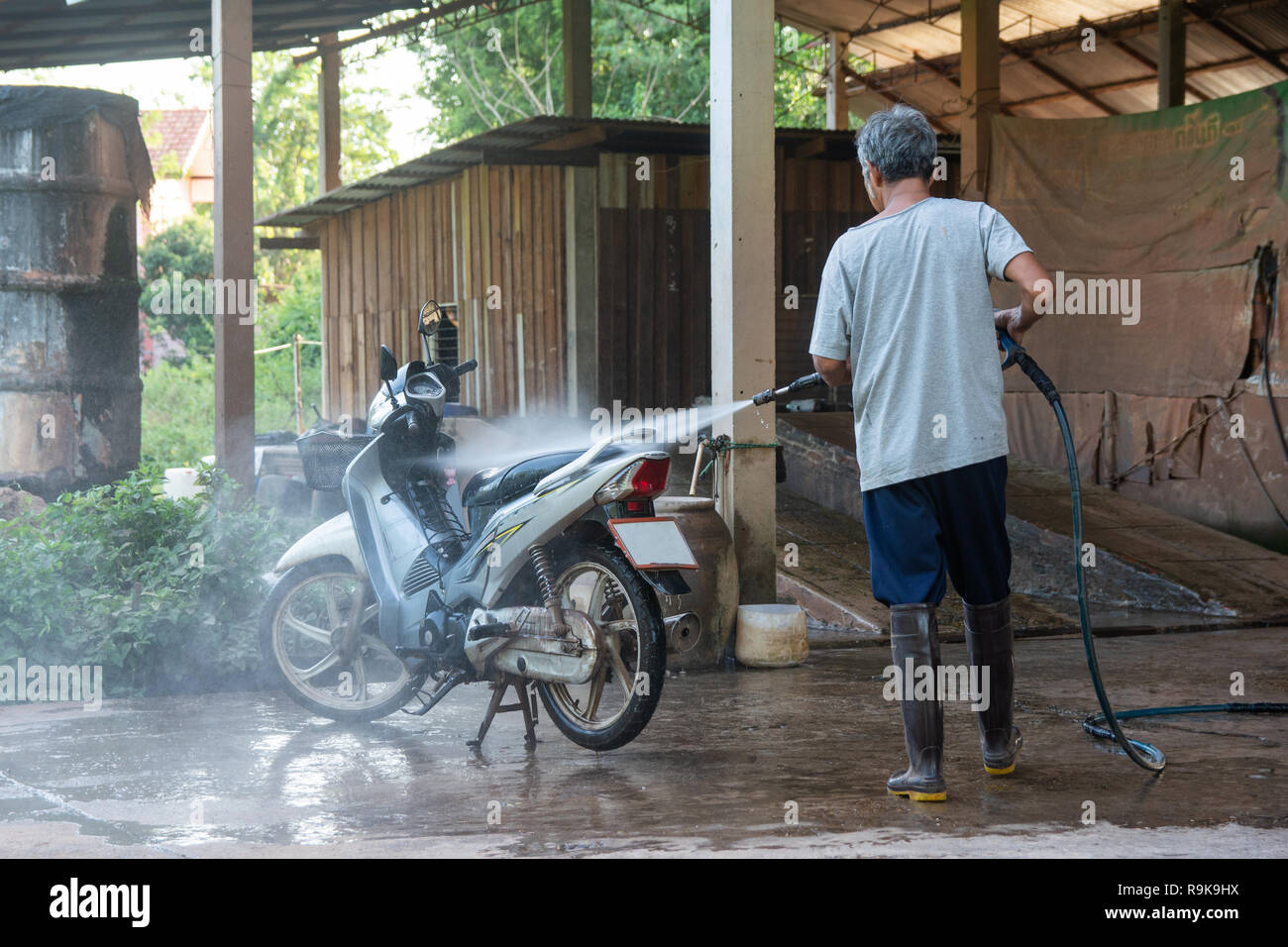 Il vecchio uomo lavare il vostro motociclo con idropulitrice ad alta  pressione in corrispondenza di lavaggio auto shop Foto stock - Alamy