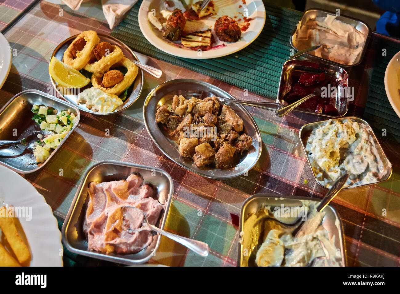 Medio orientale o piatti arabi e un assortimento di meze, concreto sfondo rustico. Spiedini di carne, falafel, Baba ghanoush, muhammara, hummus, sambusak, riso, Foto Stock