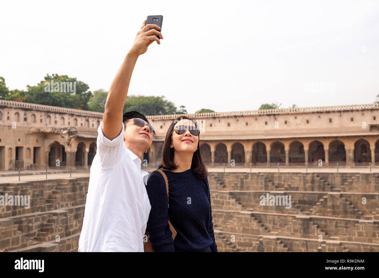 Asian giovane felice in amore tenendo selfie foto su Chand Baori stepwell in India. Foto Stock