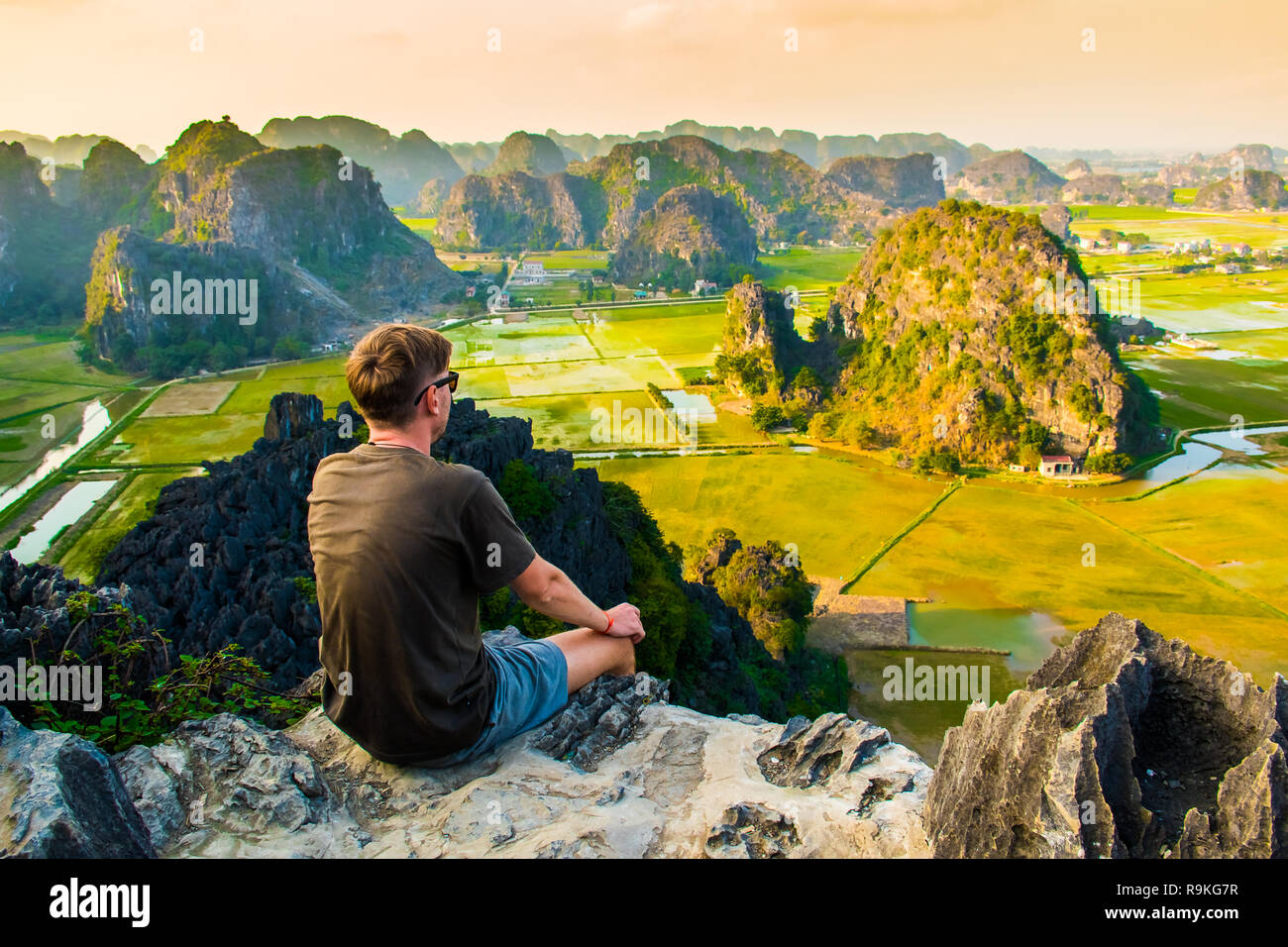 Un uomo che guarda dal tramonto stupendo paesaggio dal punto di vista della parte superiore della grotta di Mua montagna, Ninh Binh, Tam Coc in Vietnam Foto Stock