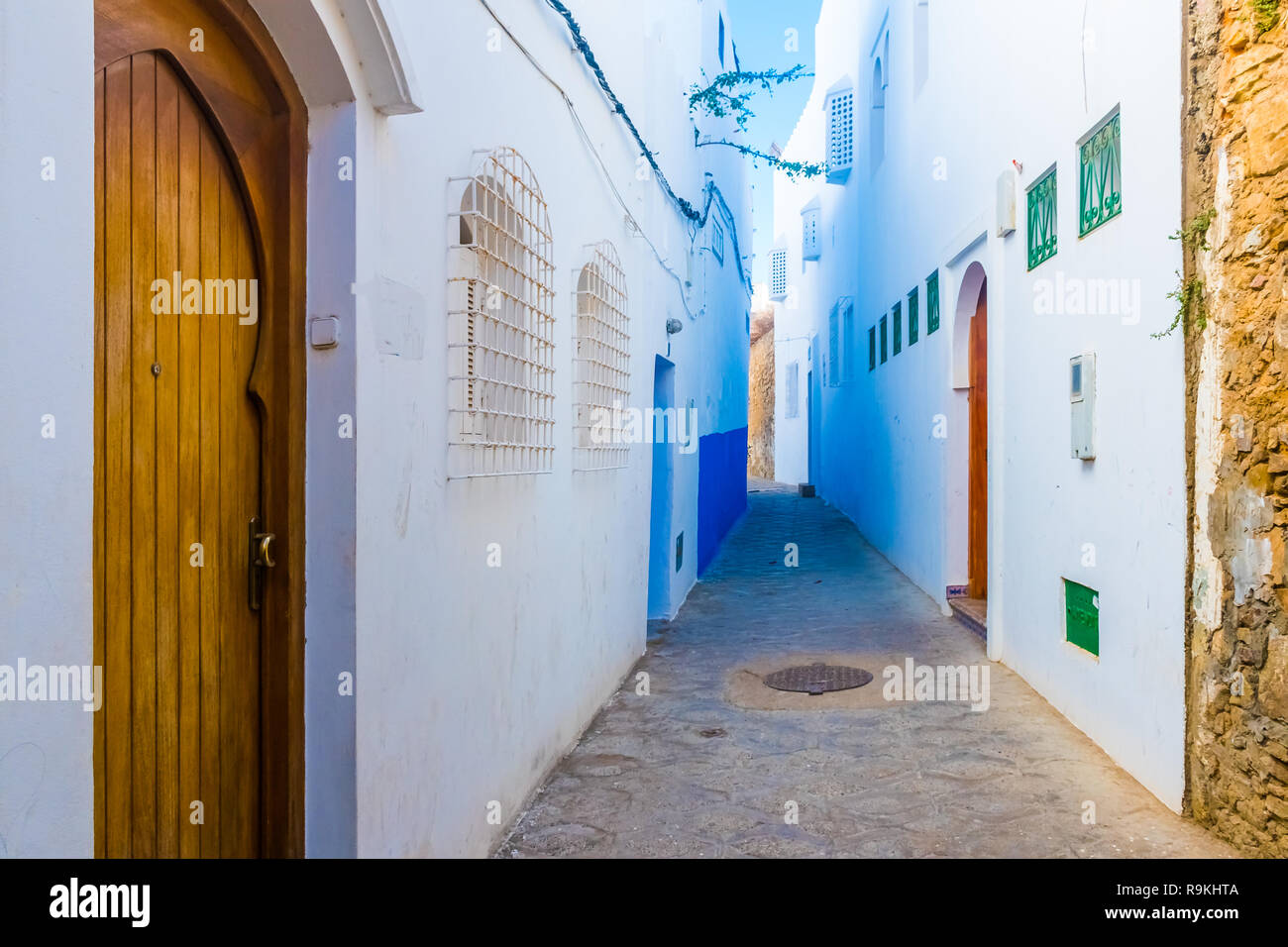 Porta e bellissima strada di bianco antica Medina di Asilah villaggio in Marocco Foto Stock