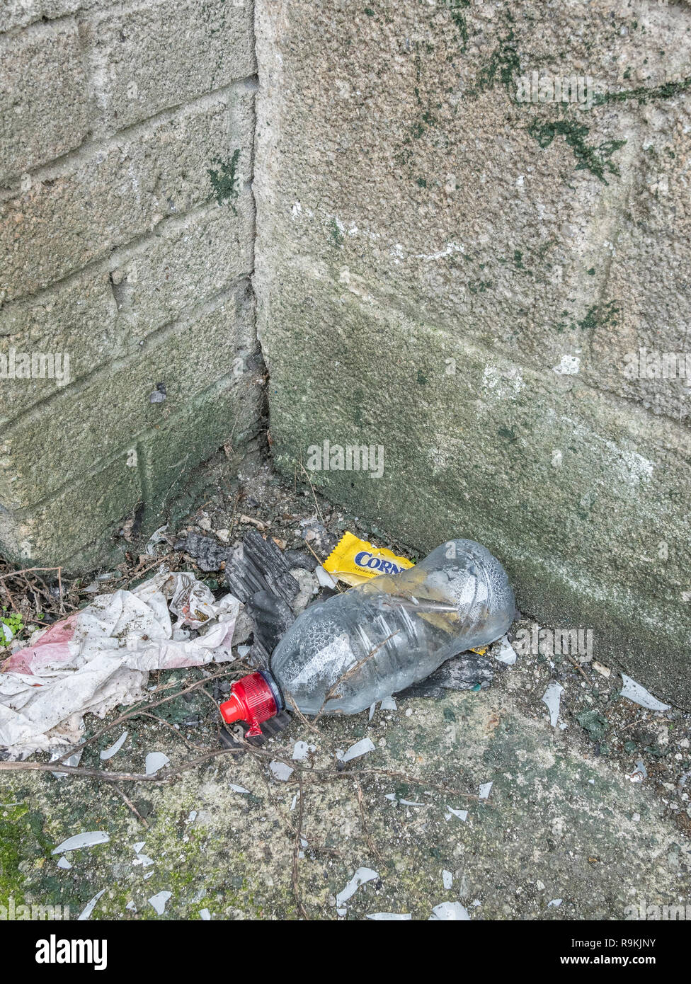 Rifiuti di plastica gettati in ambiente urbano back street. Metafora plastica inquinamento, inquinamento ambientale, guerra sulla plastica dei rifiuti, rifiuti plastici. Foto Stock