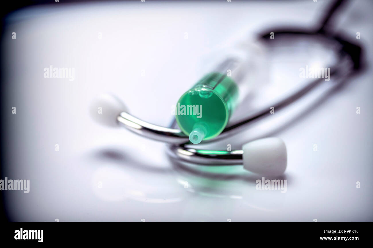 Siringa dettaglio lungo con un phonendoscope isolati su sfondo bianco Foto Stock