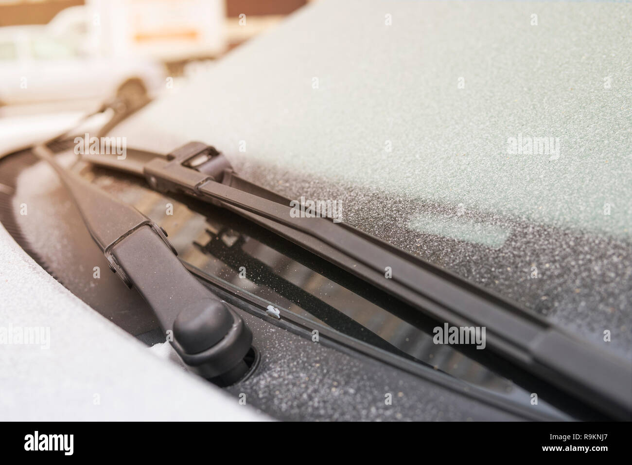 Bidello di auto si è bloccato al vetro della vettura a bassa temperatura. Problemi con la vettura in inverno. Fiocchi di neve ghiacciata su frosty auto nella fredda mattina sun Foto Stock