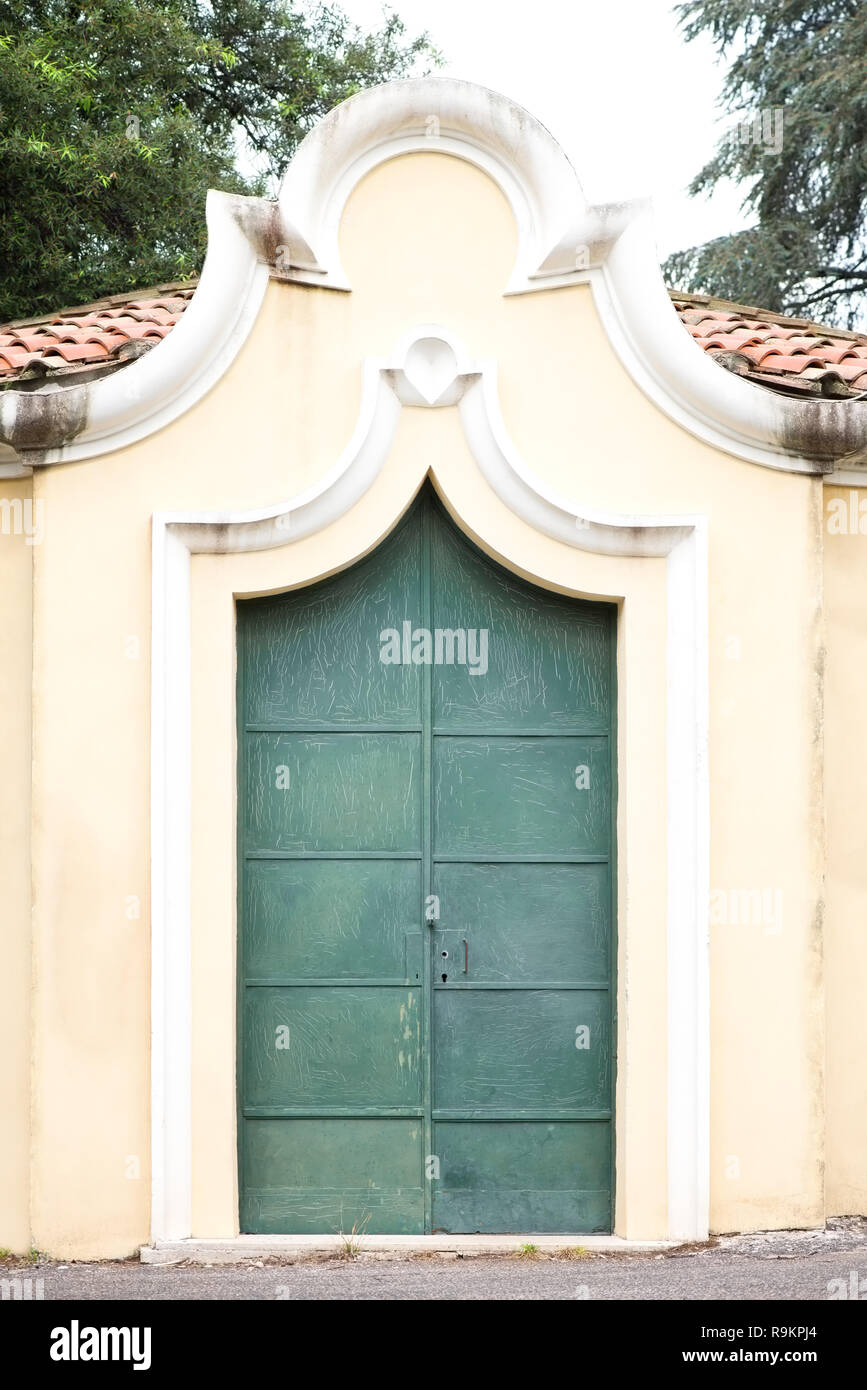 Edificio con un vecchio verde porta di metallo e gratta e vinci Foto Stock