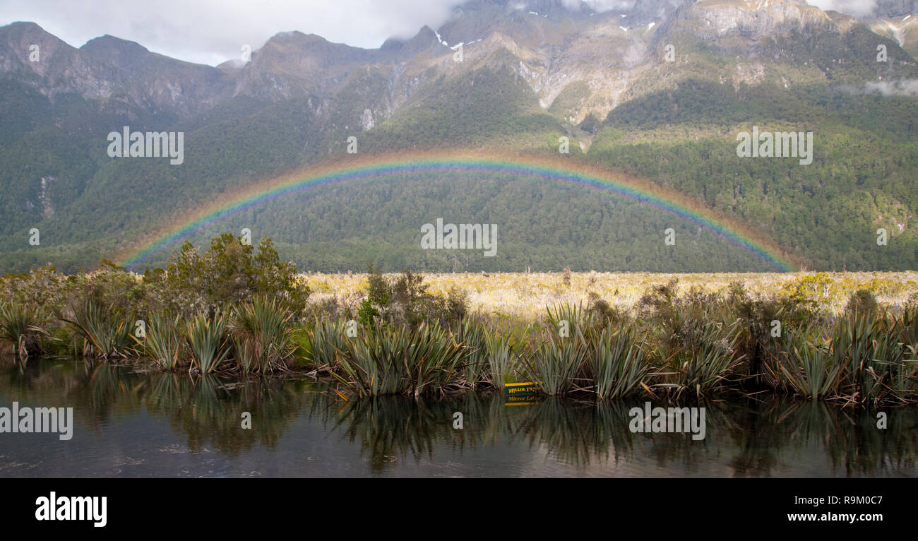 Un arcobaleno su uno dei Laghi Specchio nel Fjordland, Nuova Zelanda Foto Stock