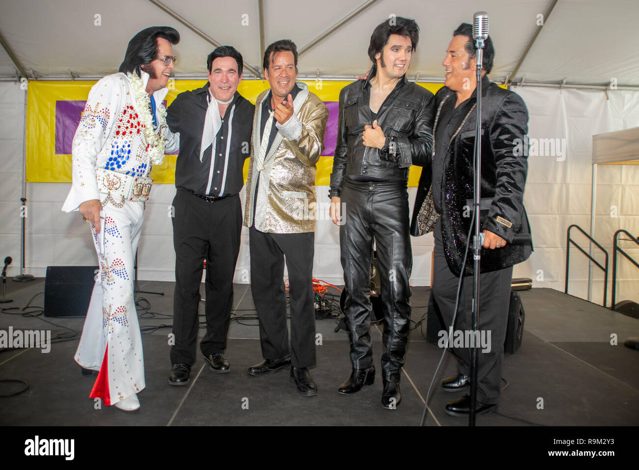 Cinque costume Elvis Presley imitatori line up sul palcoscenico di un festival di musica in Fullerton, CA. Foto Stock