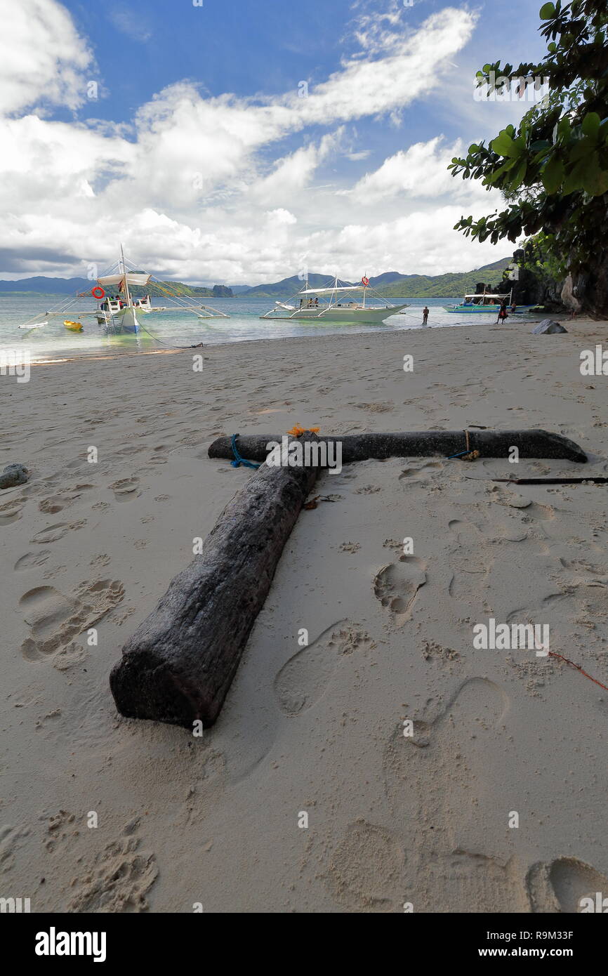 Due Palm tree le linee sulla sabbia di Cudugnon Cave Beach formando un angolo di novanta gradi rivolta verso sé verso Lagen-Dibuluan isole e Palawan ma Foto Stock