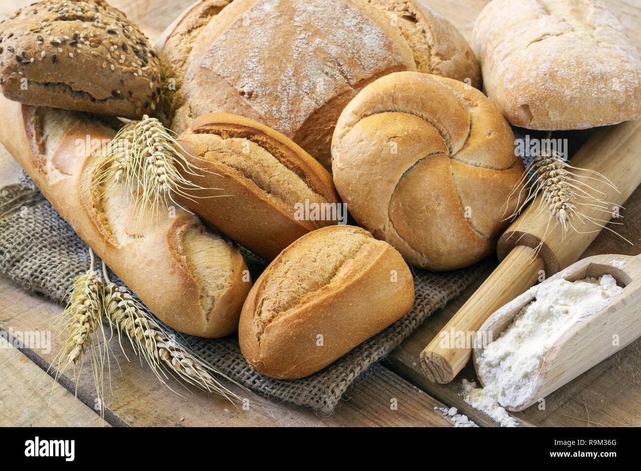 Vari tipi di pane su uno sfondo di legno Foto Stock