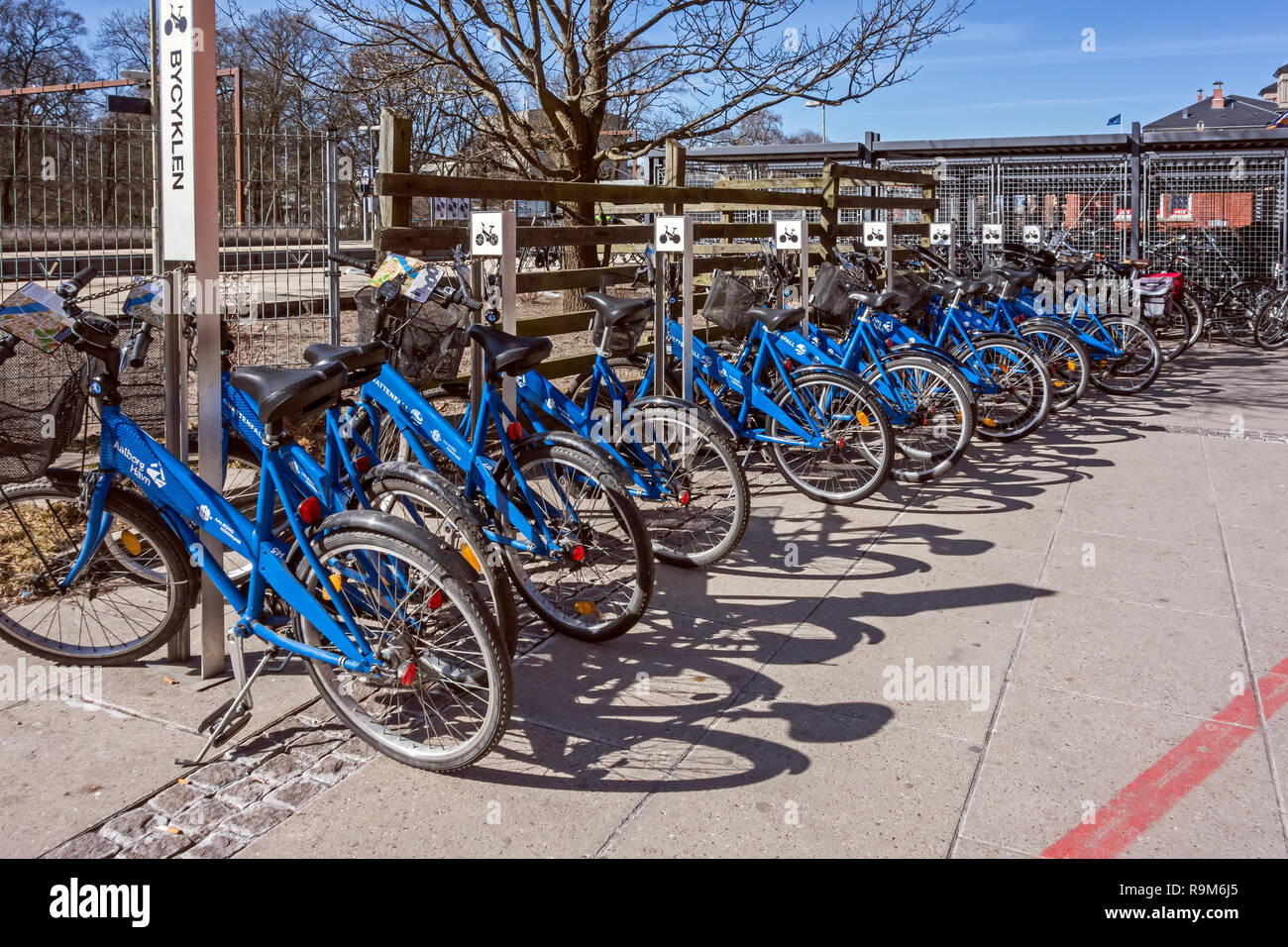 Portabiciclette con pubbliche le biciclette a noleggio presso le stazioni ferroviarie e degli autobus di John F Kennedys Plads Aalborg dello Jutland in Danimarca Europa Foto Stock