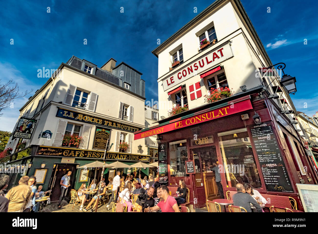 I visitatori godendo il pranzo seduti fuori il ristorante le Consulat un ristorante e bistrot su rue Norvins nel cuore di Montmartre, Parigi, Francia Foto Stock