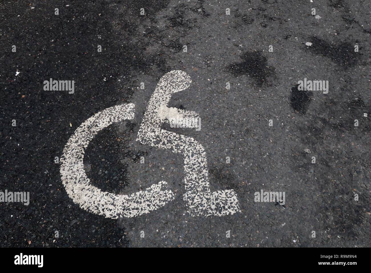 Parcheggio Disabili simbolo dipinto sul terreno. Tesco parcheggio auto. Suffolk, Regno Unito. Foto Stock