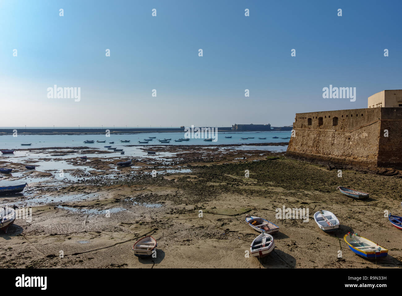La Bassa marea a Cadice con il fort e marina Foto Stock