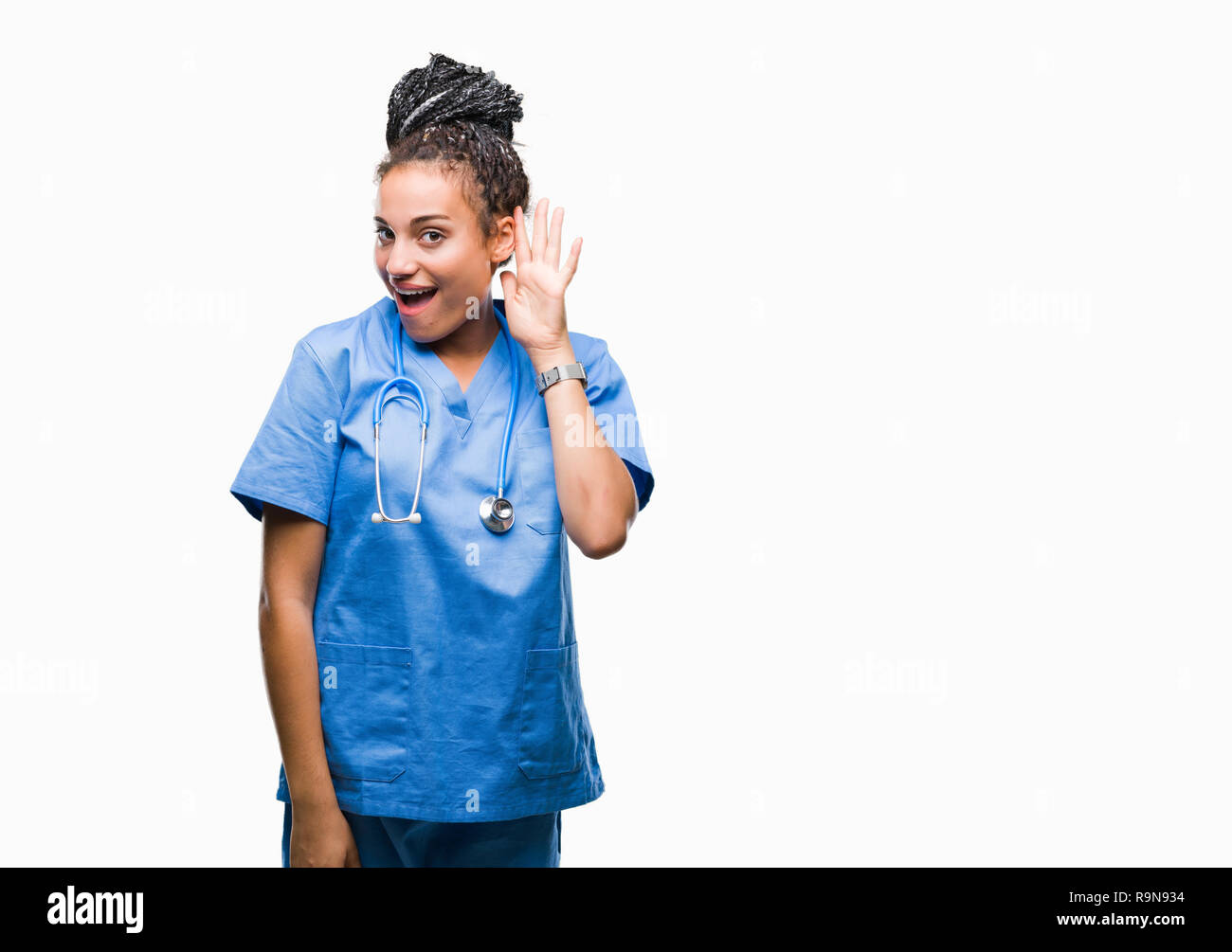 Giovani capelli intrecciati African American Girl professional chirurgo su sfondo isolato sorridente con la mano sul orecchio in ascolto di un audizione di rumor o gos Foto Stock