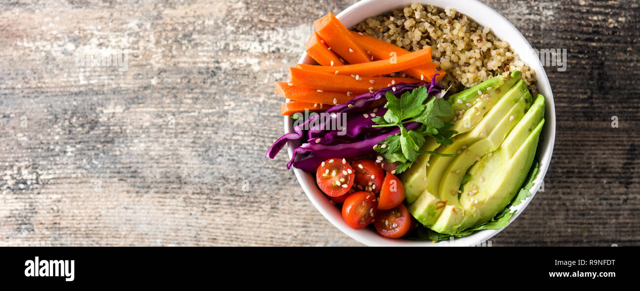 Buddha vegano ciotola con fresche verdure crude e quinoa sul tavolo di legno. Vista panoramica. Copyspace Foto Stock
