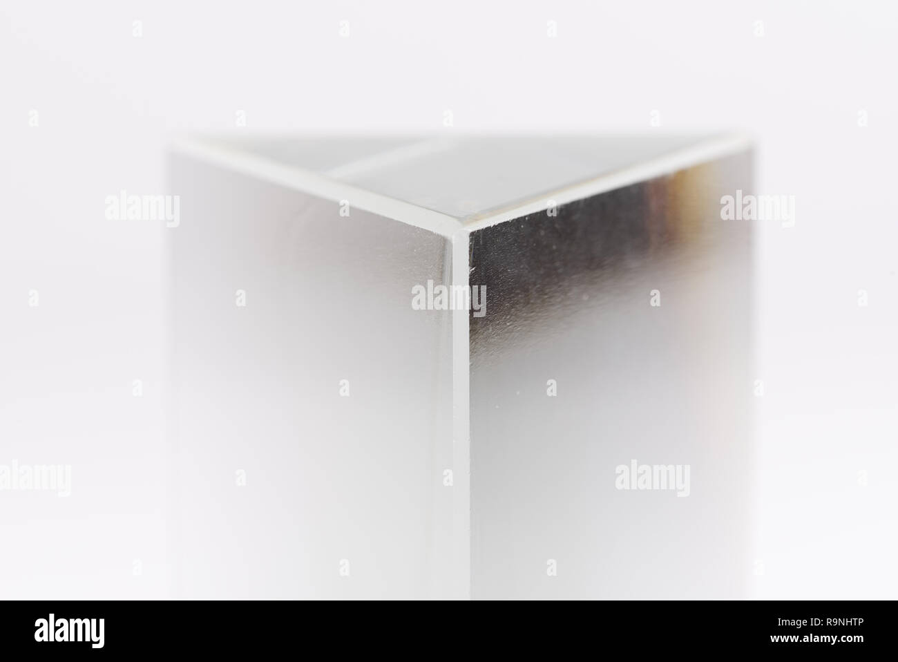 Triangolare, chiaro prisma di vetro isolato su uno sfondo bianco. Foto Stock