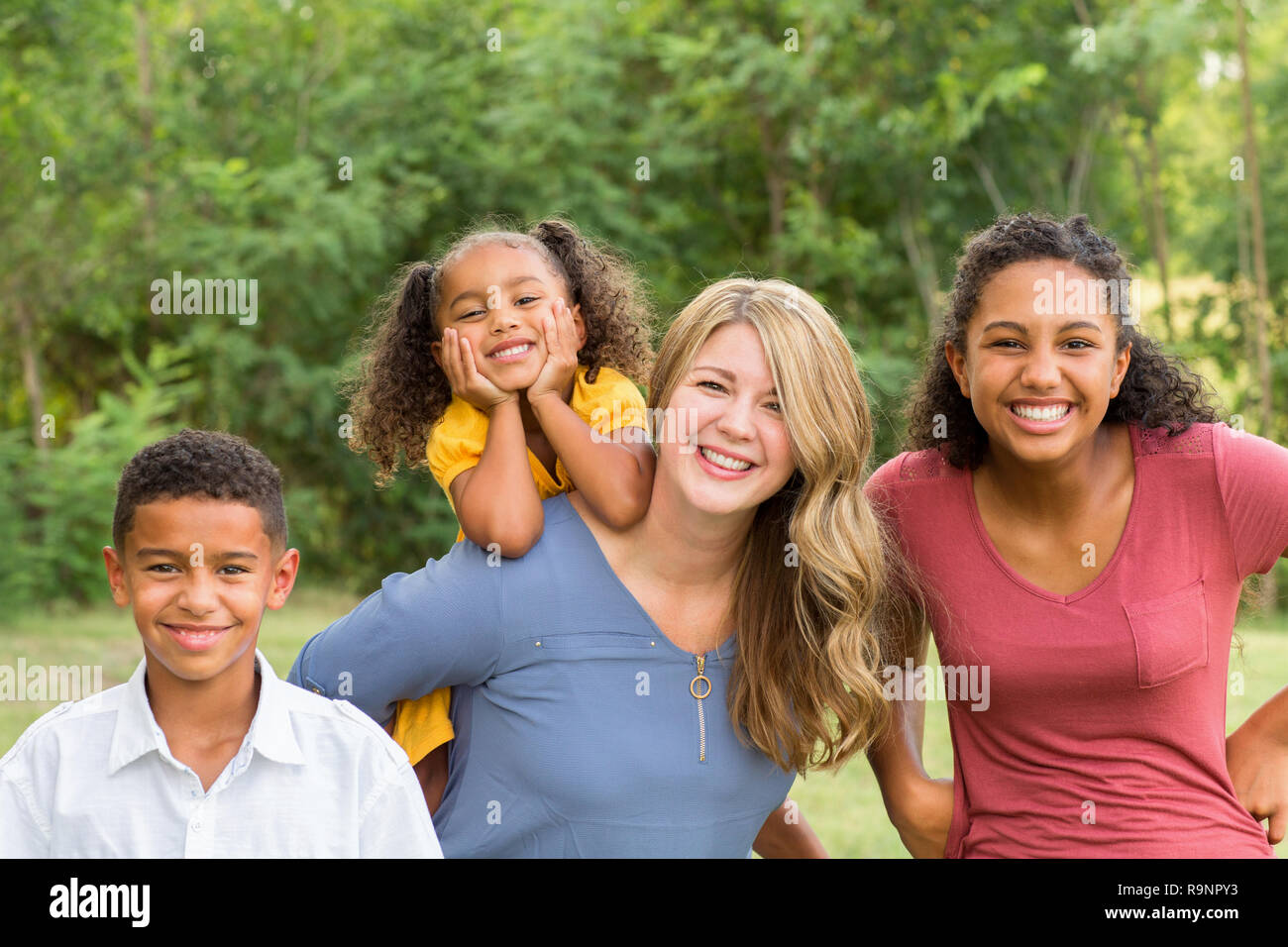 Portarit di una felice razza mista famiglia sorridente Foto Stock