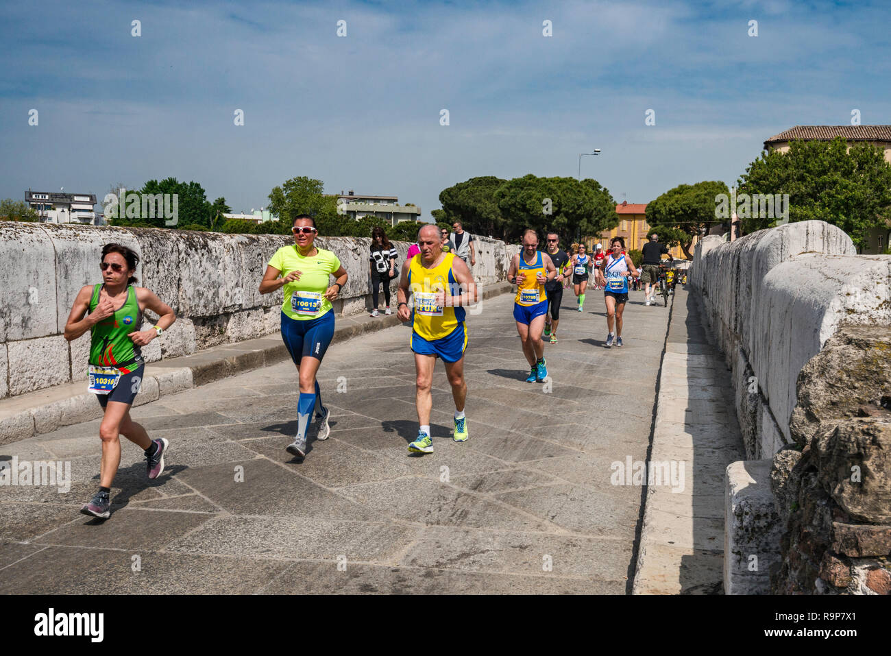 Guide a dieci miglia a correre attraversando il Ponte di Tiberio (Ponte di Tiberio), AD 21, ponte romano a Rimini, Emilia Romagna, Italia Foto Stock