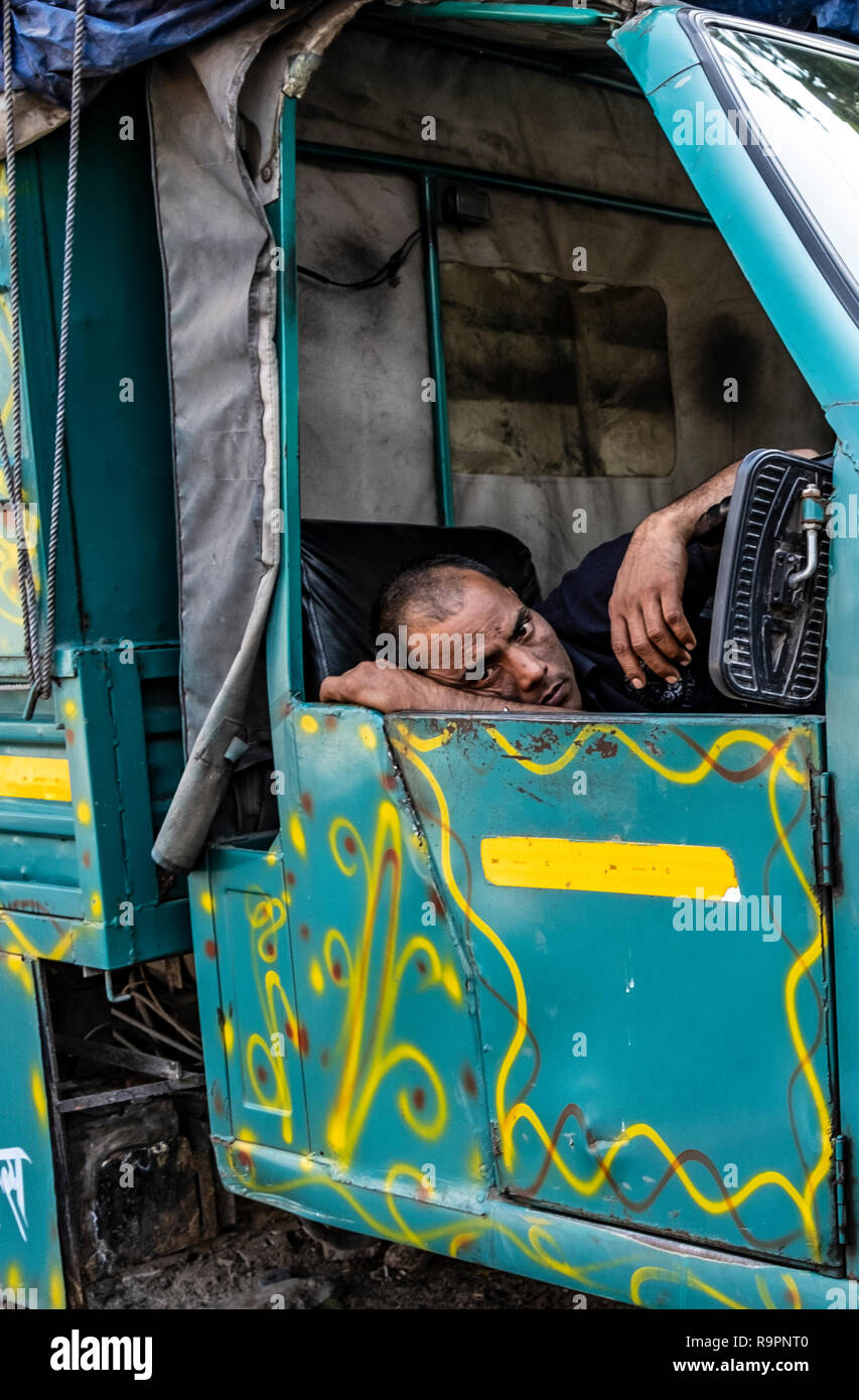 Un driver autorickshaw disturbata durante un pisolino. Foto Stock