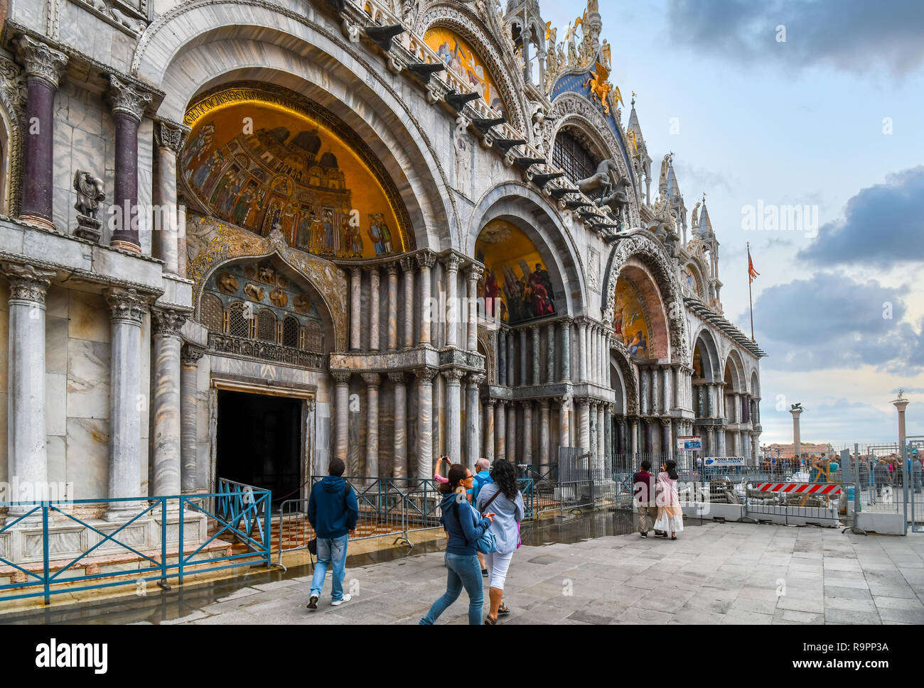 I turisti passano alla Basilica di San Marco Cattedrale in Piazza San Marco con le colonne di San Marco e San Todaro in vista di Venezia, Italia Foto Stock