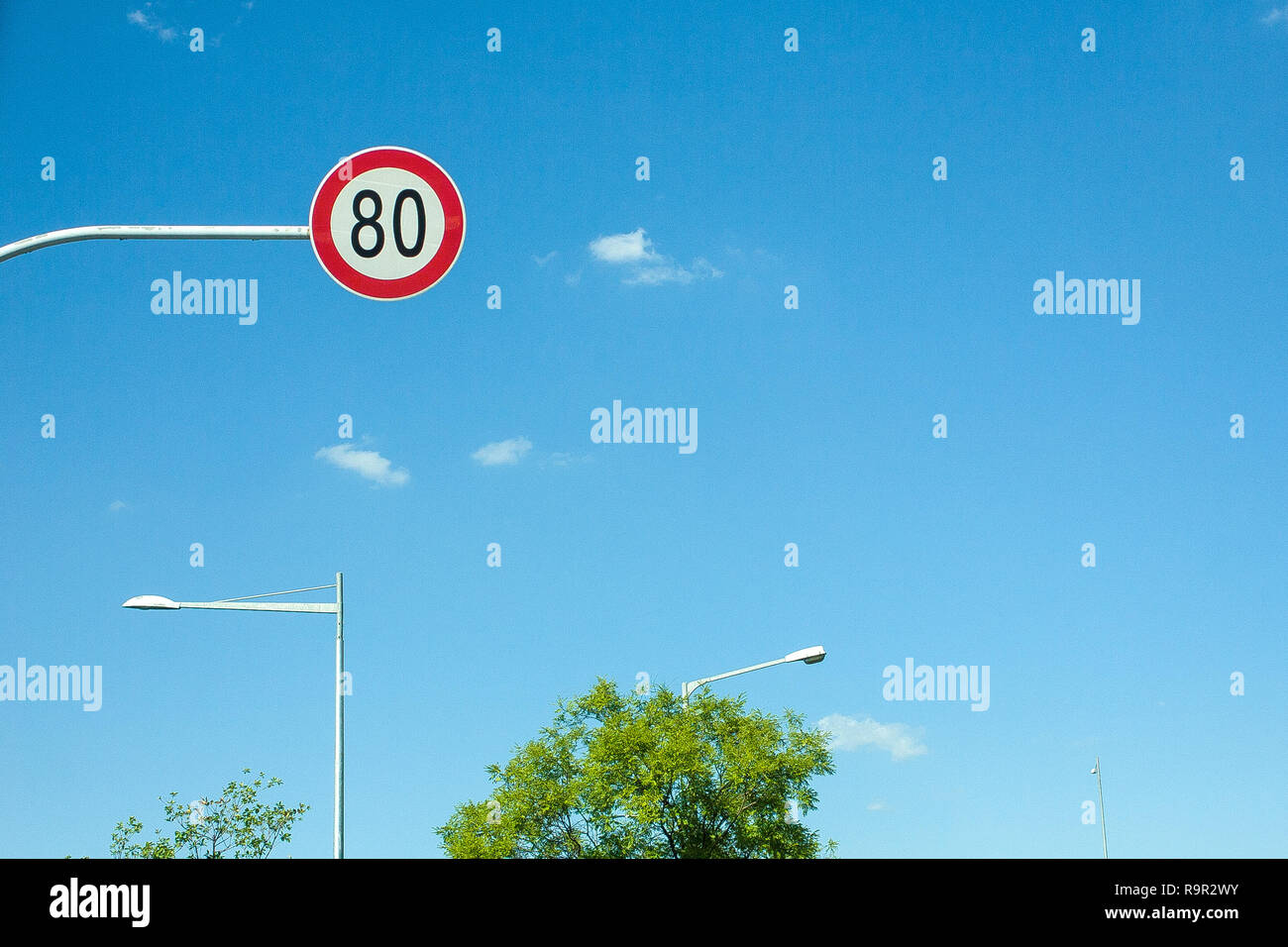 Il limite massimo di velocità segni e lampioni. Cielo blu e nuvole. Foto Stock