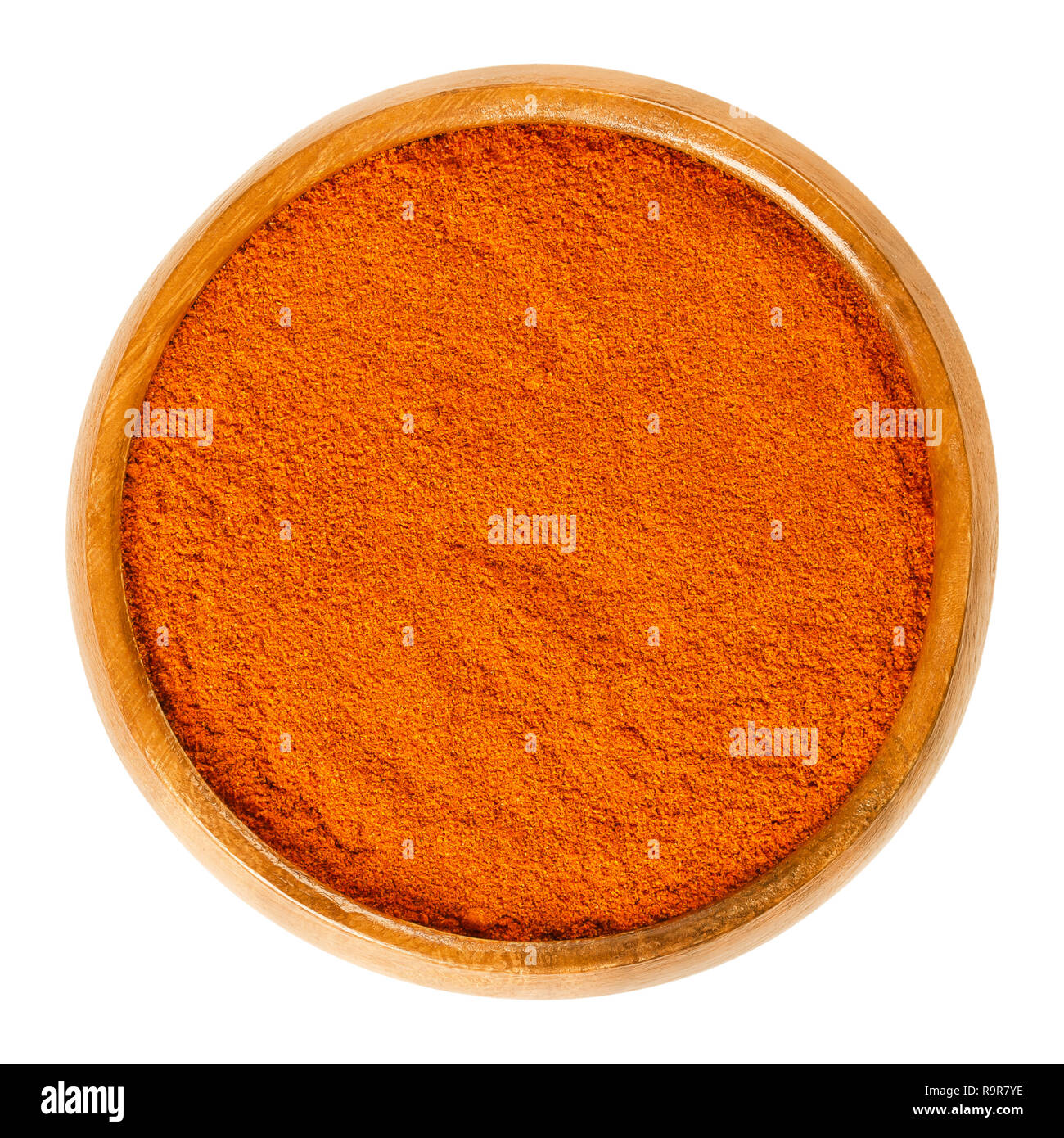 Il pepe di cayenna in polvere nella ciotola di legno. Spice. Moderatamente hot chili pepper colore rosso utilizzato per insaporire le pietanze. Essiccata e macinata frutti di Capsicum annuum Foto Stock