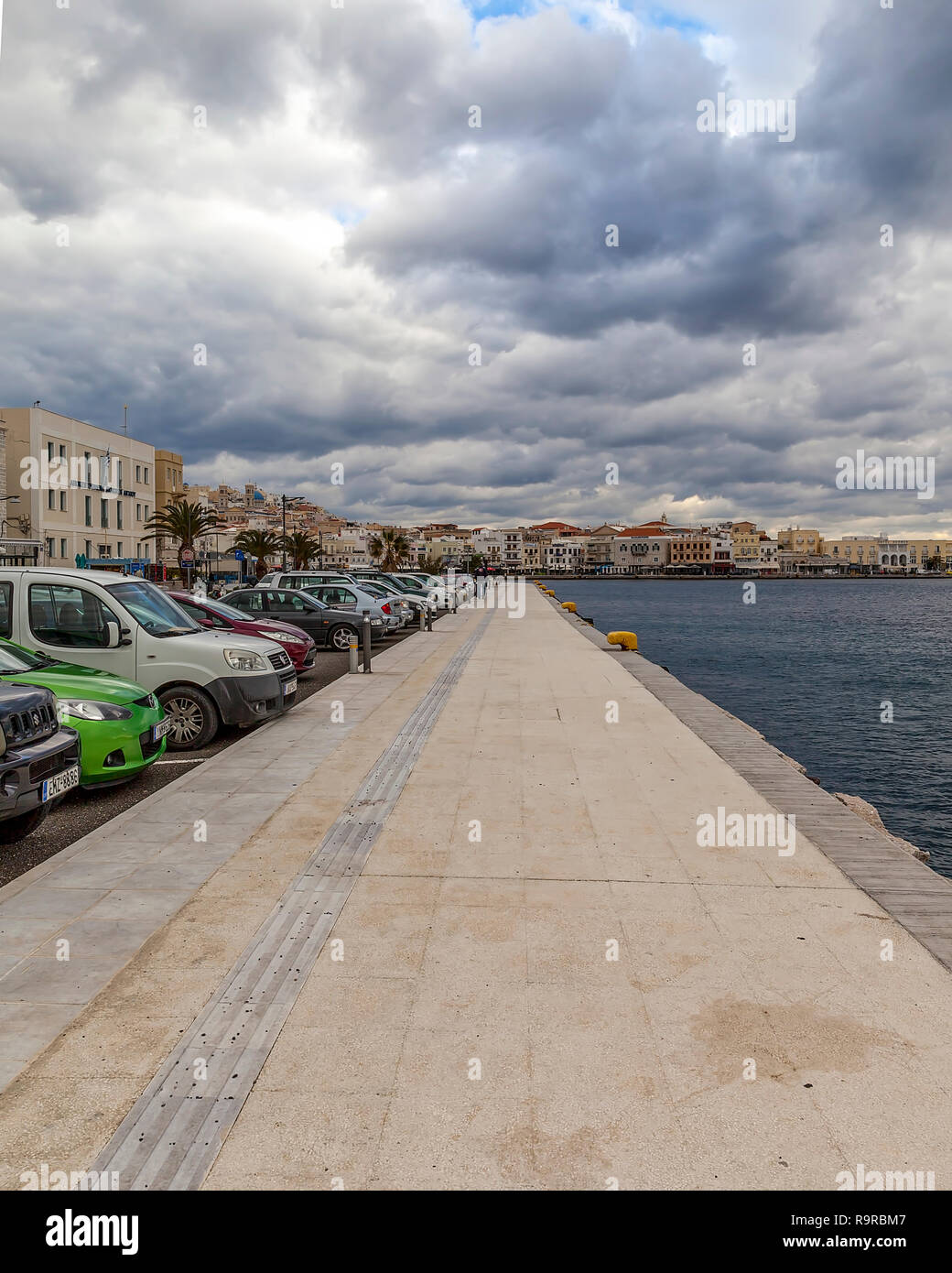 Ermoupolis: Dicembre 27th. Downtown Ermoupolis harbour con vetture parcheggiate sulla sinistra vicino al porto. Ermoupolis 27th, Ermoupolis, Syros Grecia 2018. Foto Stock