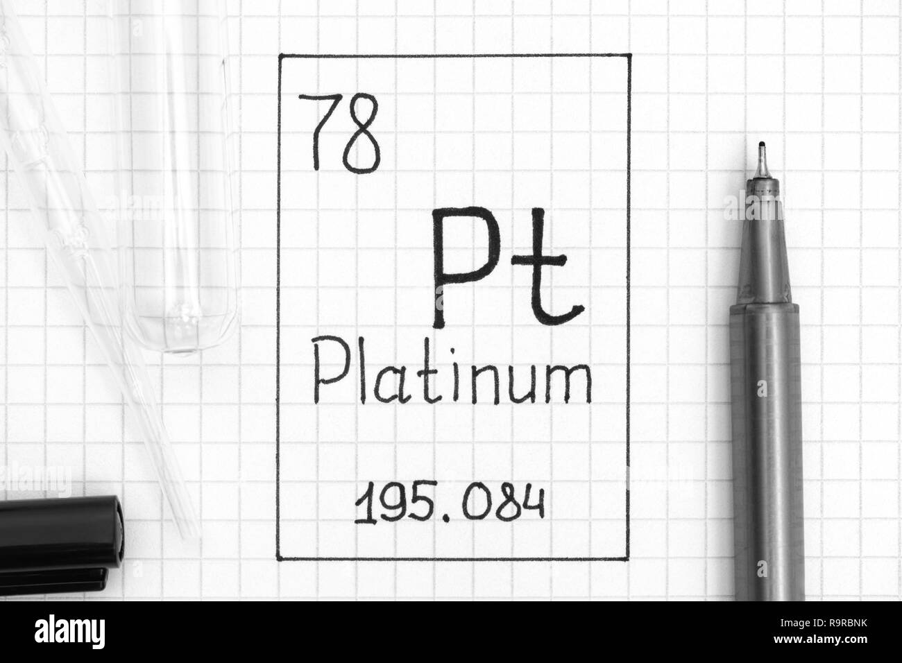 Tavola periodica degli elementi. La grafia elemento chimico di platino Pt con la penna nera, tubo di prova e la pipetta. Close-up. Foto Stock