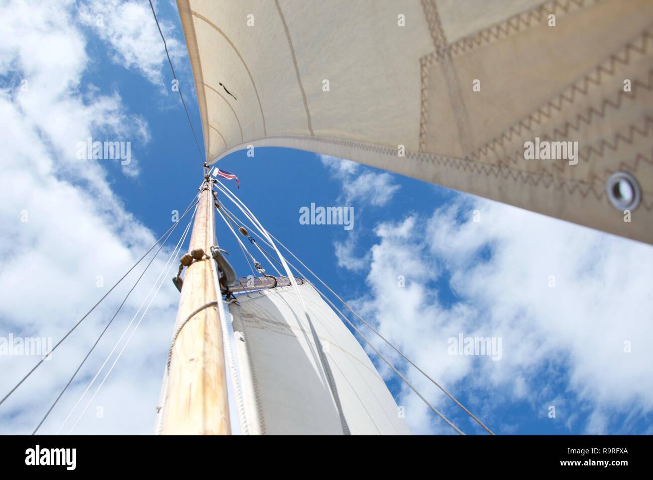 Cercando il montante su un tradizionale gaff truccate yacht / Barca a vela, contro un cielo azzurro con poche nuvole bianche. È ventoso e luminosa e la fo Foto Stock