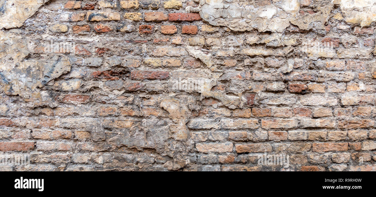 Vecchio vintage sporchi la parete in mattoni con peeling gesso sfondo texture. Foto Stock