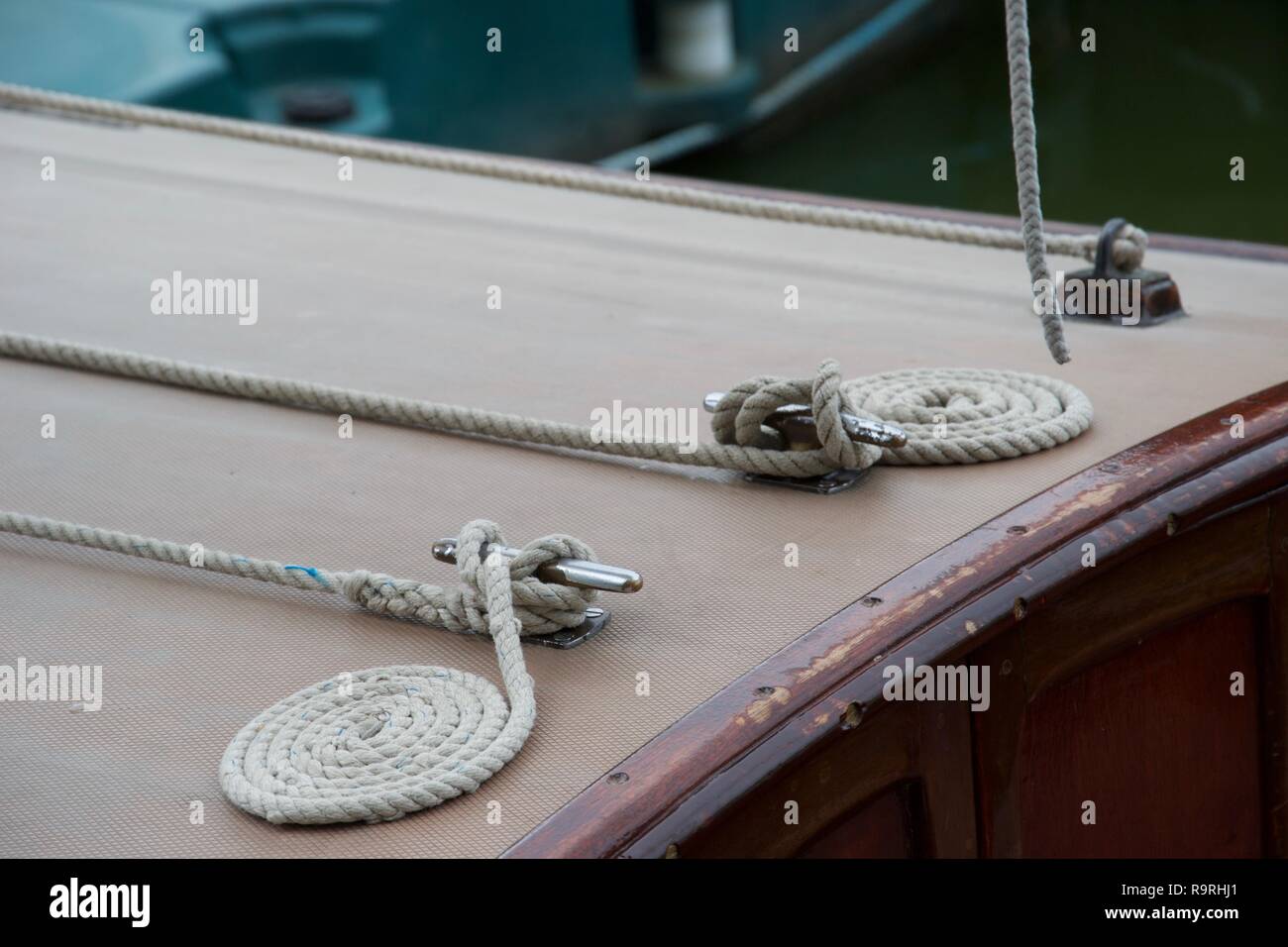 Dettaglio della perfetta, ordinato avvolto funi accanto a gancetti sul ponte di una barca di legno Foto Stock