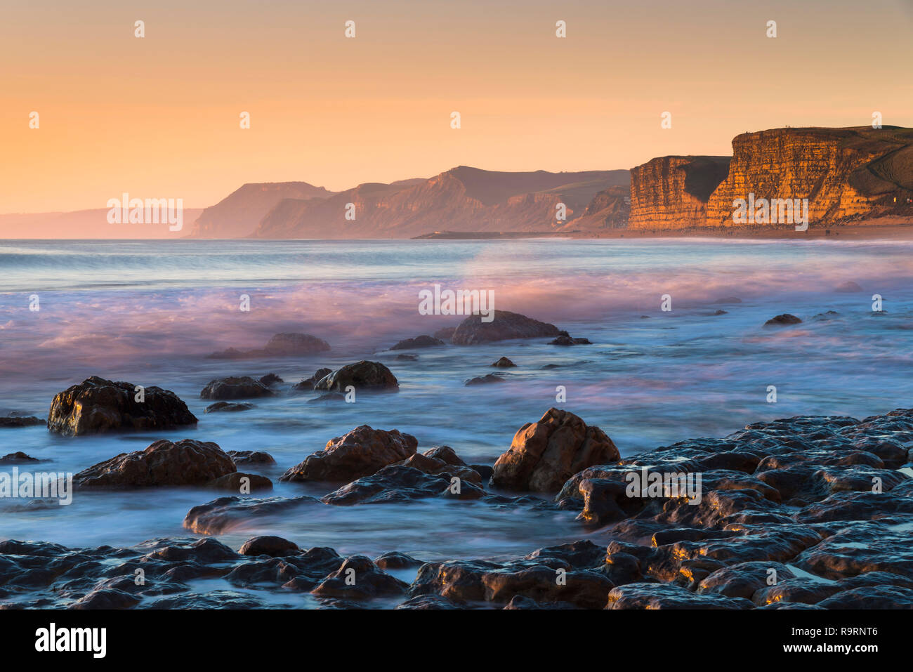 Burton Bradstock, Dorset, Regno Unito. Il 27 dicembre 2018. Regno Unito Meteo. Vista da ovest la spiaggia di Burton Bradstock sul Dorset Jurassic Coast guardando verso il West Bay e Golden Cap al tramonto. Credito Foto: Graham Hunt/Alamy Live News Foto Stock