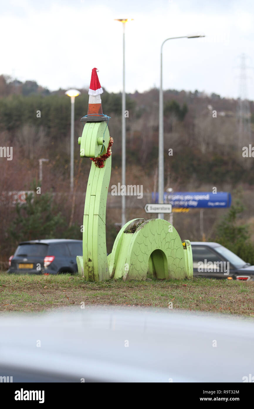 Inverness, Scotland, Regno Unito. Il 29 dicembre 2018. Burloni hanno vestito un punto di riferimento del mostro di Loch Ness in un cono stradale, Santa hat e un tinsel collana. Il legno Nessie è in corrispondenza di una rotatoria sulla strada per il Lago di Loch Ness da Inverness, vicino al negozio Tesco sulla Dores road. L'aggiunta di traffico cono al Nessie landmark è simile al normale aggiunta di un cono stradale per il Duca di Wellington statua in Glasgow. Credito Foto: Andrew Smith/Alamy Live News Foto Stock