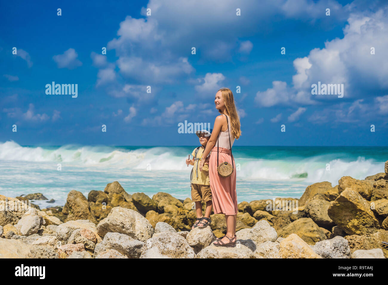 Madre e figlio i viaggiatori su Melasti incredibile spiaggia con acque turchesi, isola di Bali Indonesia. Viaggiare con bambini concept Foto Stock