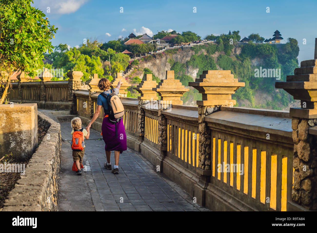 Papà e figlio i viaggiatori in Pura Luhur Uluwatu temple, Bali, Indonesia. Un paesaggio fantastico - scogliera con il blu del cielo e del mare. Viaggiare con bambini concept Foto Stock