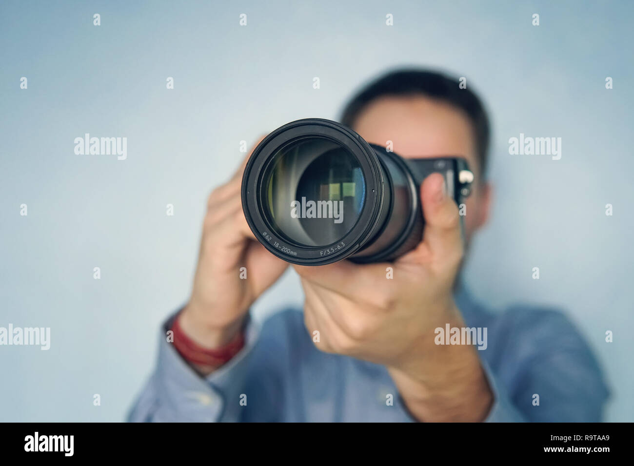 Fotografo maschio photoshooting contro una parete blu sullo sfondo. copyspace, copia, spazio Foto Stock
