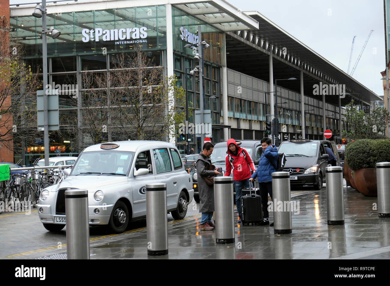 Visualizzare i passeggeri e i bagagli uscendo di taxi alla stazione di St Pancras building Pancras Road a Kings Cross & tourist bus grande Londra UK KATHY DEWITT Foto Stock