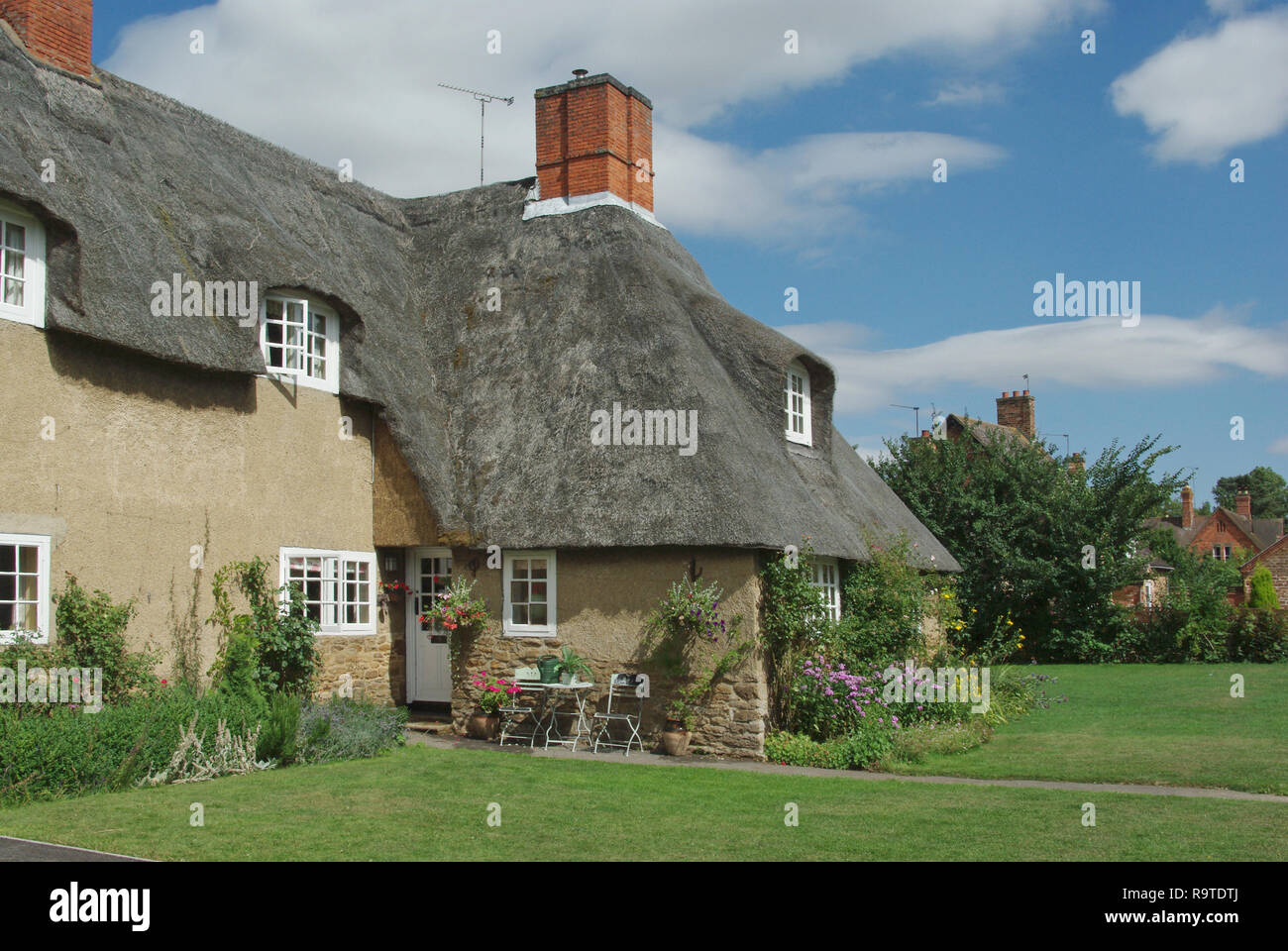 Una pittoresca terrazza del cottage con il tetto di paglia nel villaggio di Ashby St partitari, Northamptonshire, Regno Unito; costruita nei primi anni del XX secolo da Sir Edwin Lutyens. Foto Stock