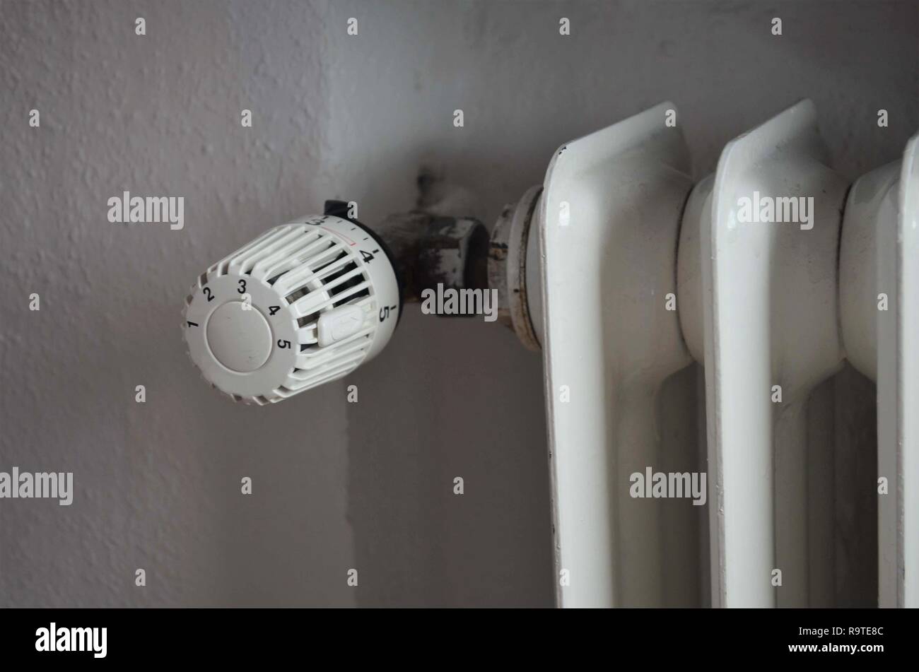 Simbolo per le spese di riscaldamento attraverso un vecchio radiatore, riscaldatore Foto Stock