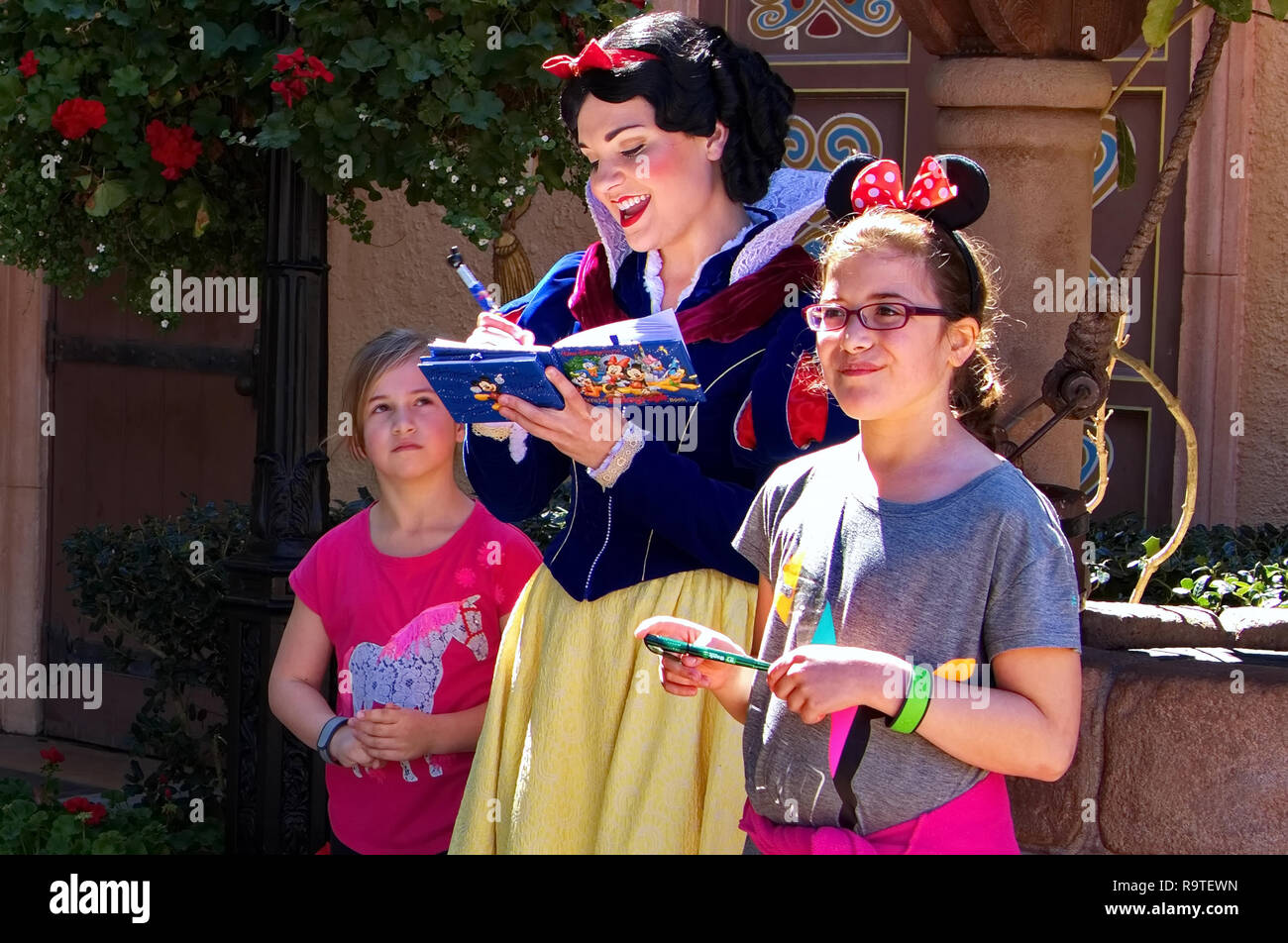 Orlando, FL, Stati Uniti d'America. Feb 2016. Una ragazza la curiosità di guardare a Snow White mentre firma la sua memoria Maker prenota a Disney World. Foto Stock