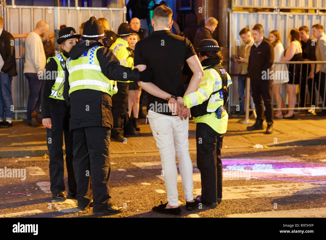 Nella foto: un uomo viene posto in stato di detenzione da funzionari di polizia. Venerdì 14 Dicembre 2018 Re: festaioli nel vento Street, Swansea, Wales, Regno Unito. Foto Stock