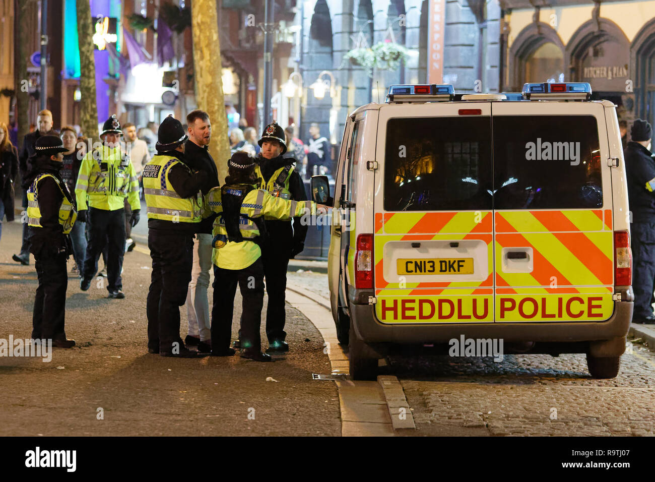 Nella foto: un uomo viene posto in stato di detenzione da funzionari di polizia. Venerdì 14 Dicembre 2018 Re: festaioli nel vento Street, Swansea, Wales, Regno Unito. Foto Stock